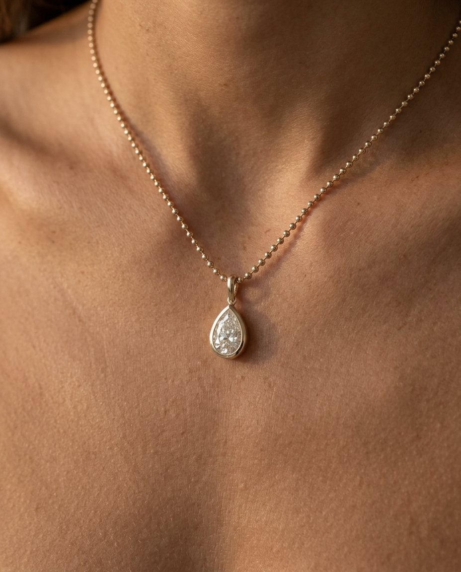 Pear pendant worn at the collarbone