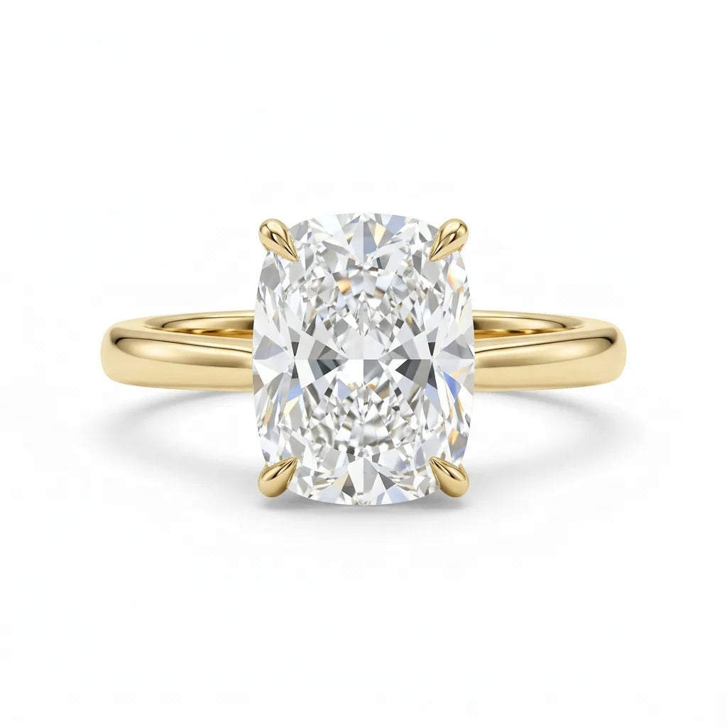 Elongated cushion-cut diamond solitaire ring on a polished 18k yellow gold band on a white studio background