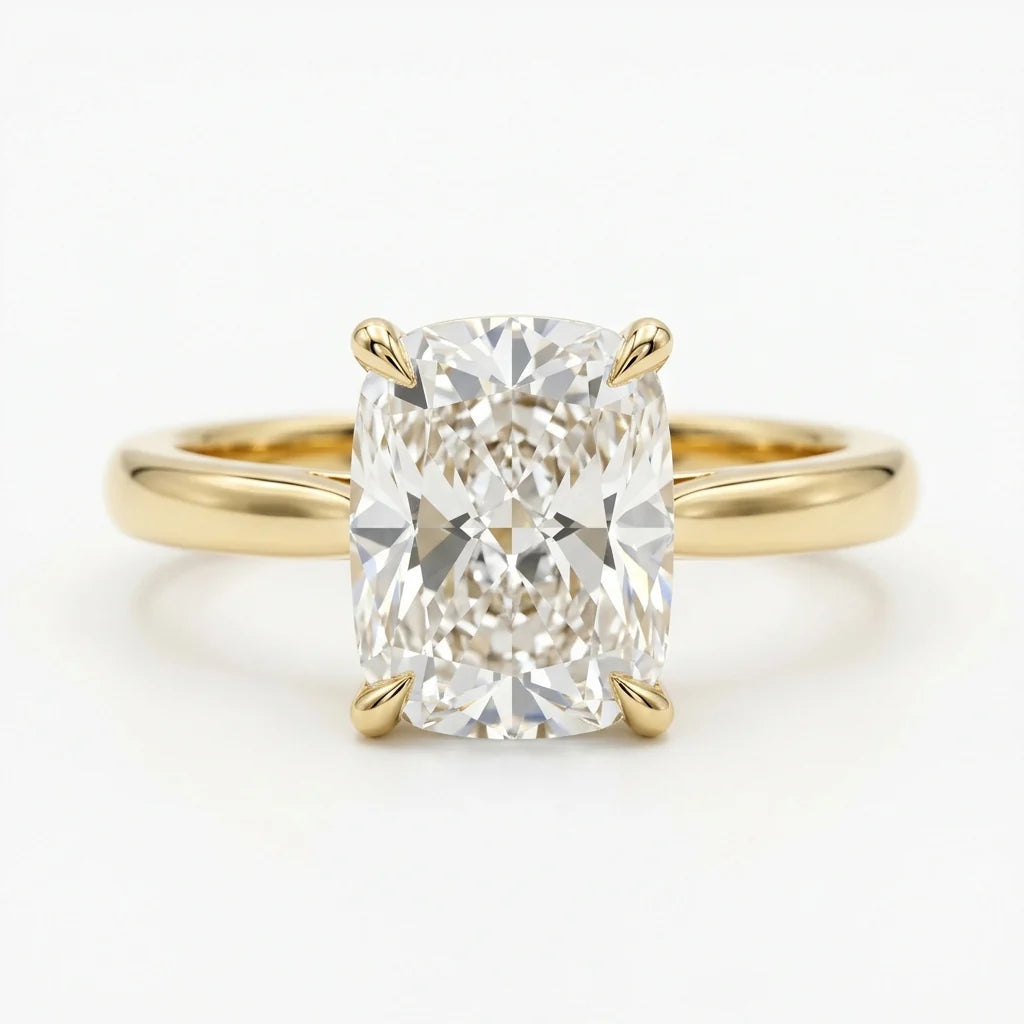 Elongated cushion-cut diamond solitaire ring on a polished 18k yellow gold band on a white studio background