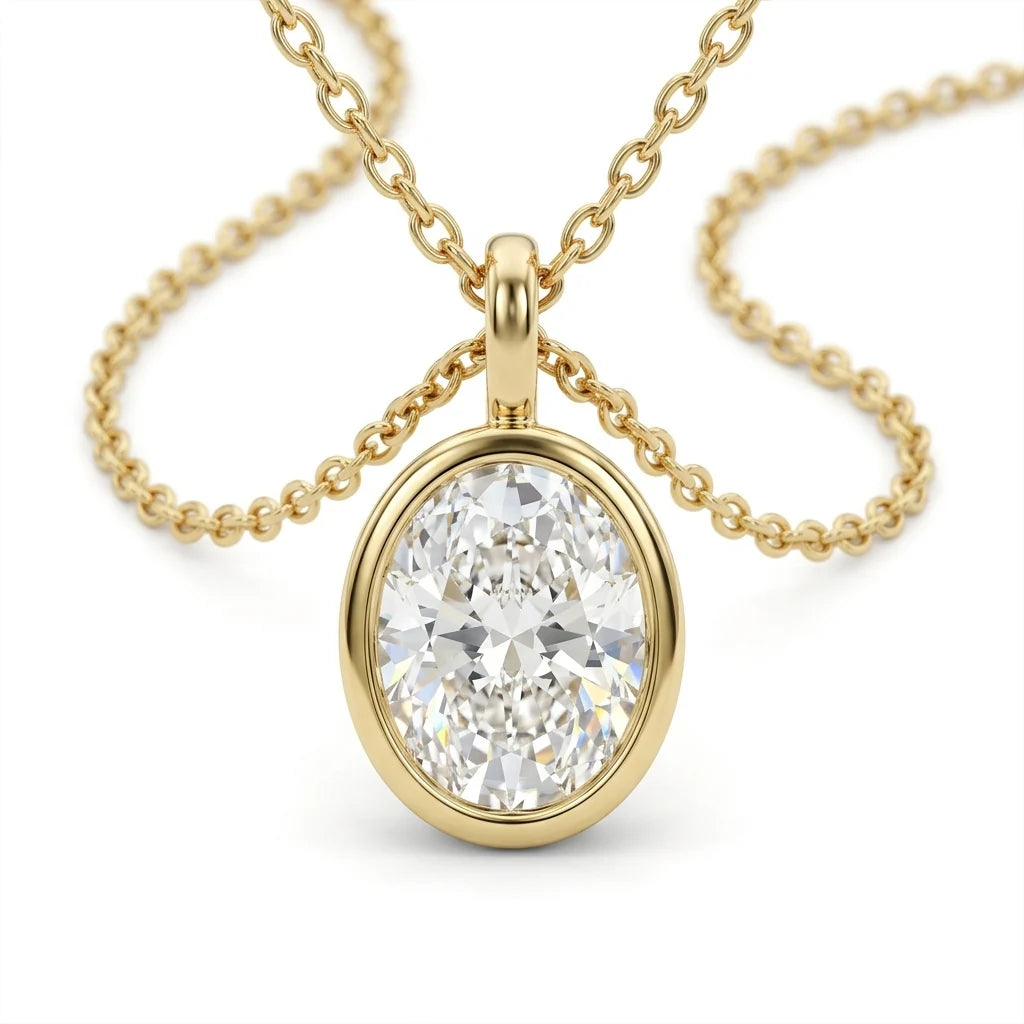 Oval-cut diamond solitaire pendant in an 18k yellow gold bezel on a fine chain, photographed on a white studio background