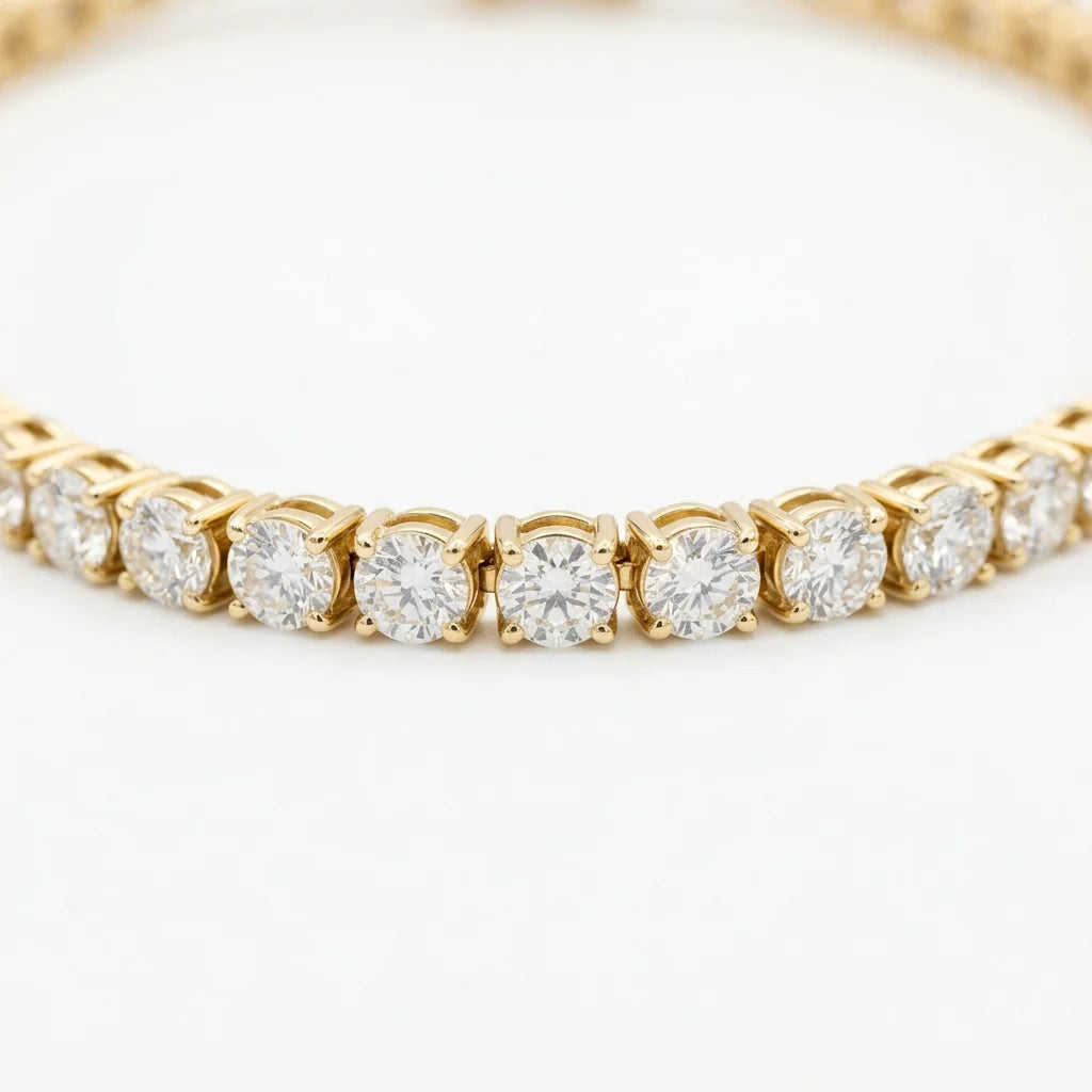 Round brilliant diamond tennis bracelet in 18k yellow gold with a box clasp on a white studio background